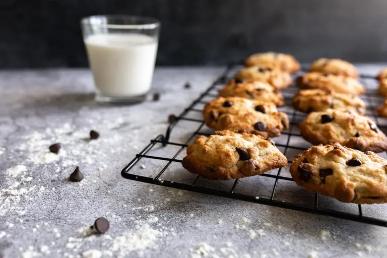 Cookies aux pépites de chocolat sur grille de refroidissement avec un verre de lait